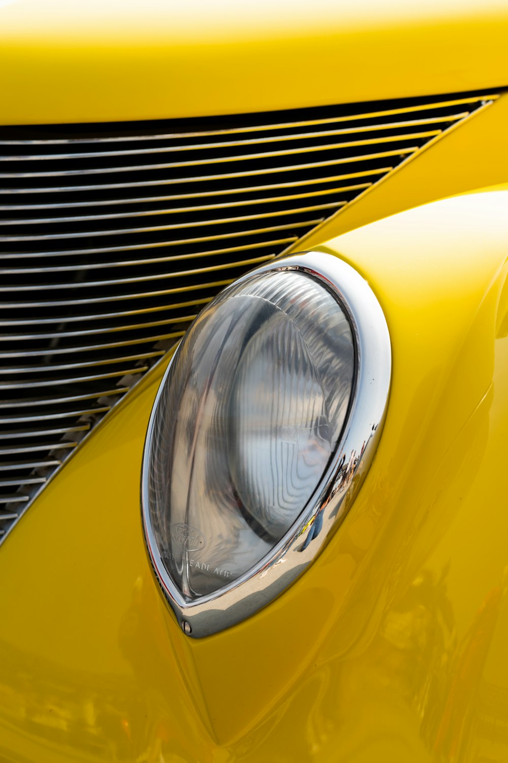 a close up of the front end of a yellow car