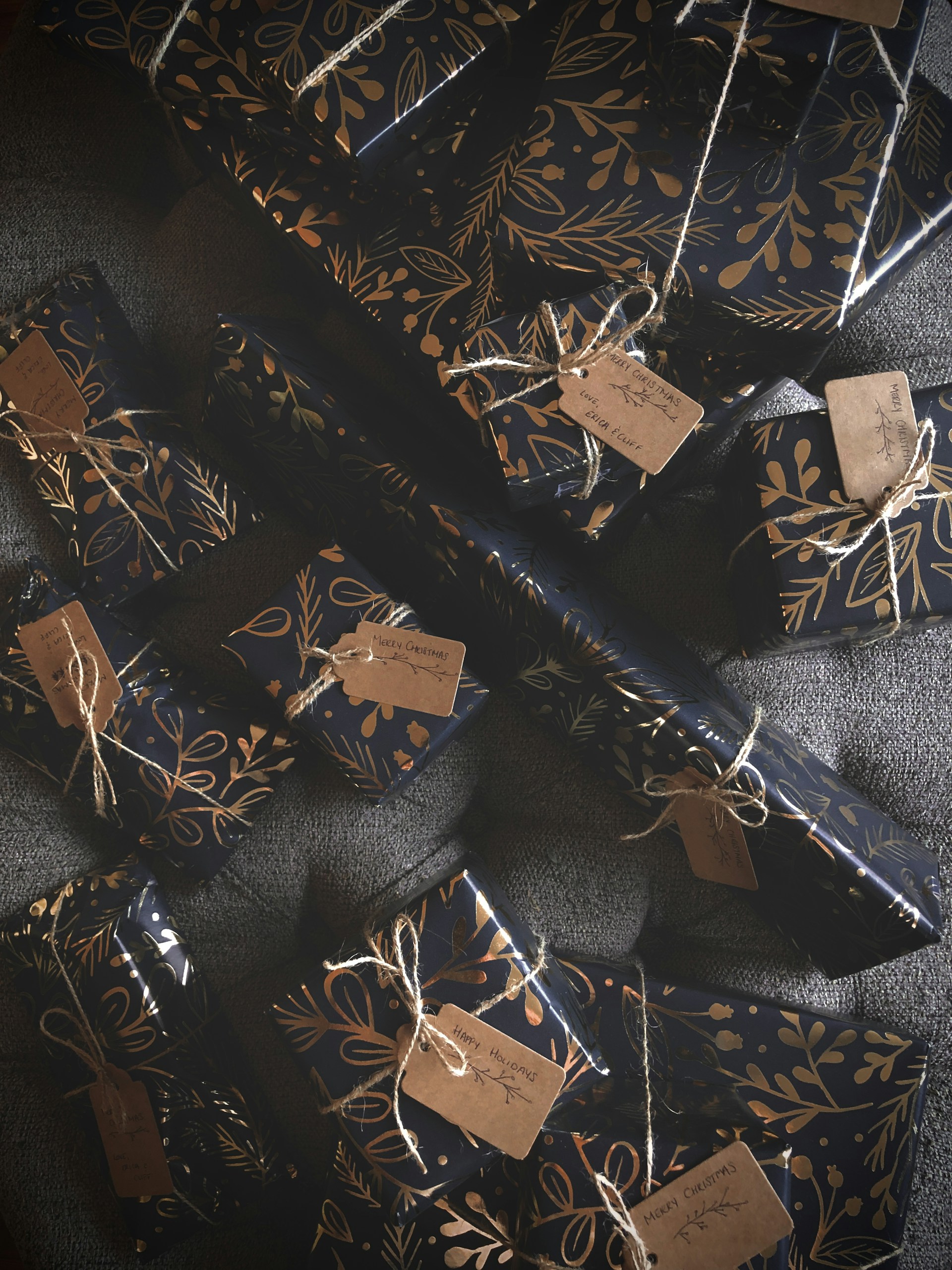 a bunch of wrapped presents with tags on them