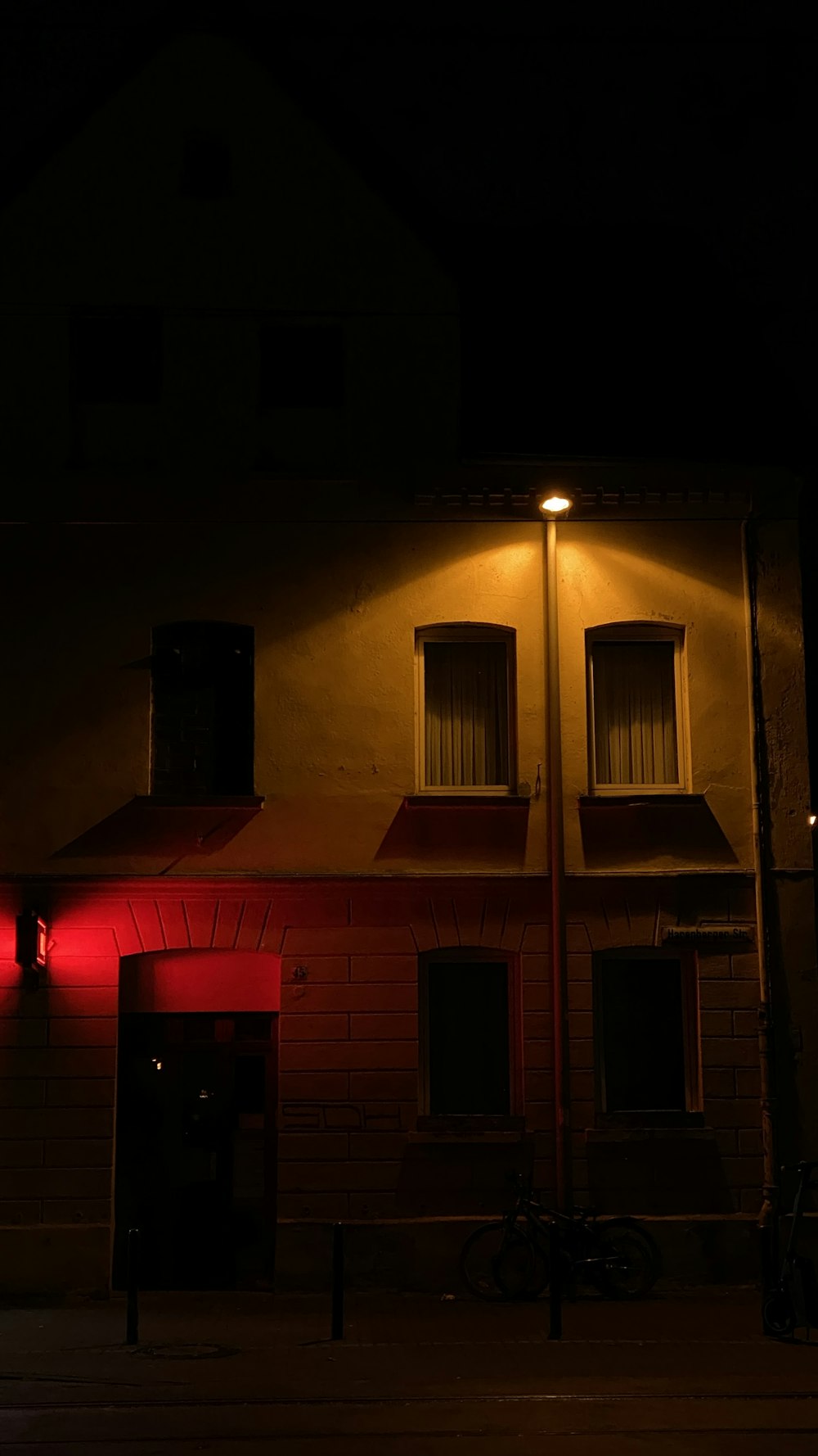 a red light shines on the side of a building