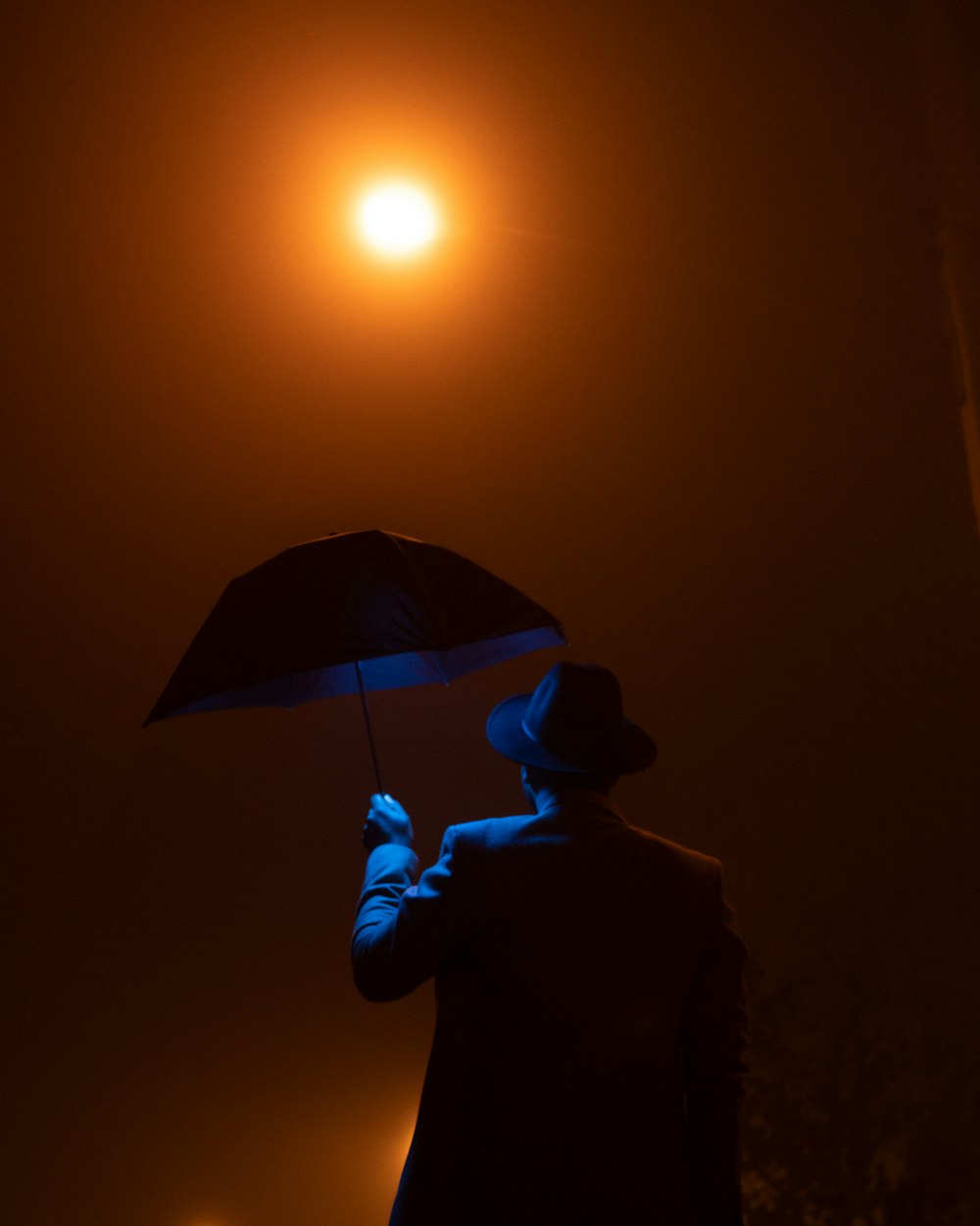 a man holding an umbrella in the dark