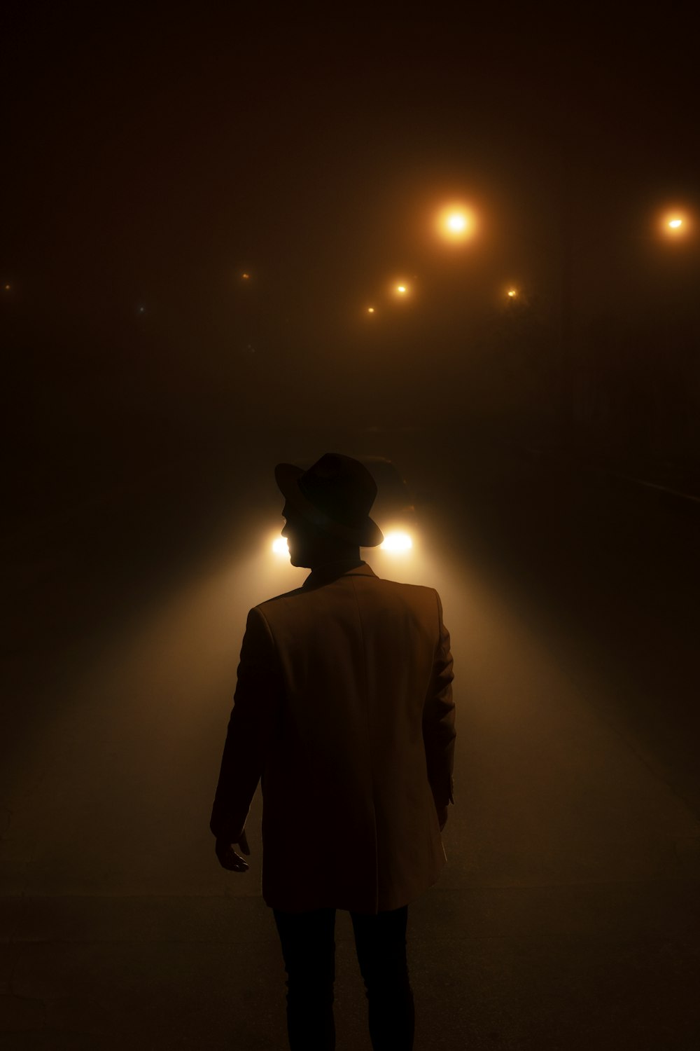 a man standing in the middle of a street at night