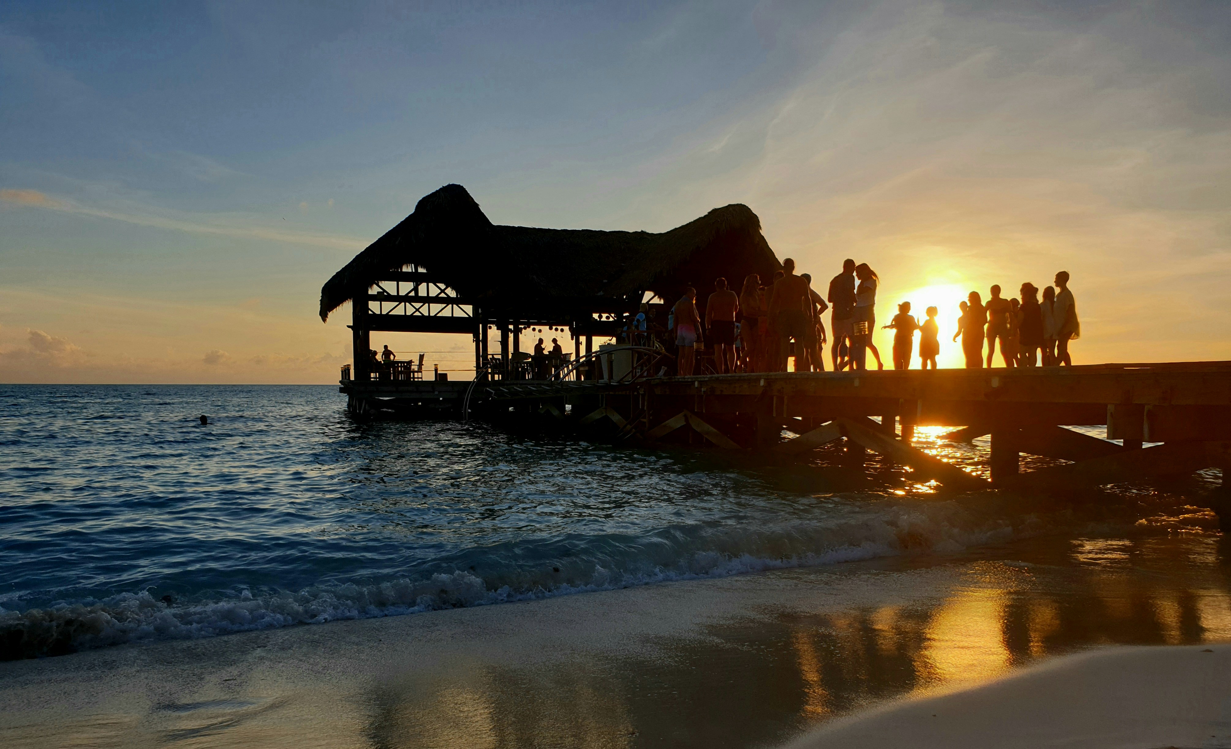 a group of people standing on top of a pier
