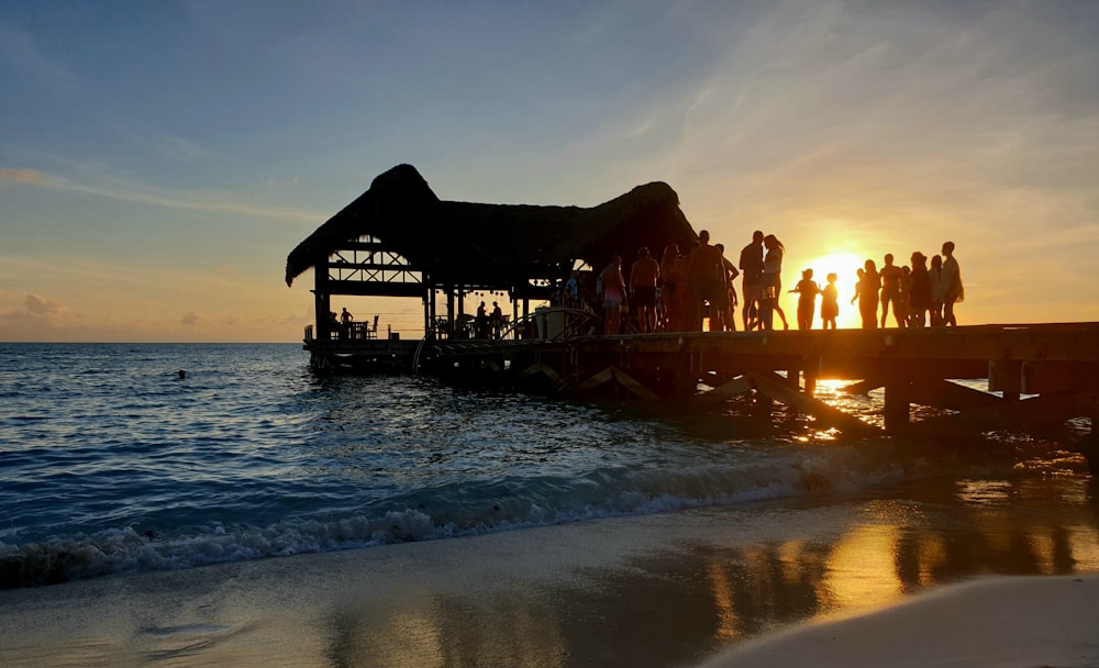 a group of people standing on top of a pier