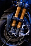 Set of shiny motorcycle brake discs and suspension springs displayed neatly