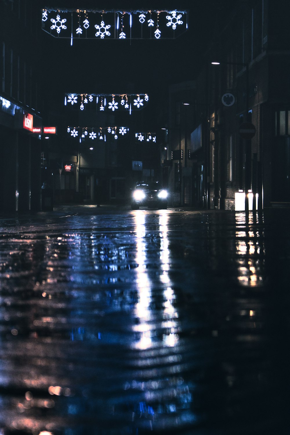 a car driving down a wet street at night