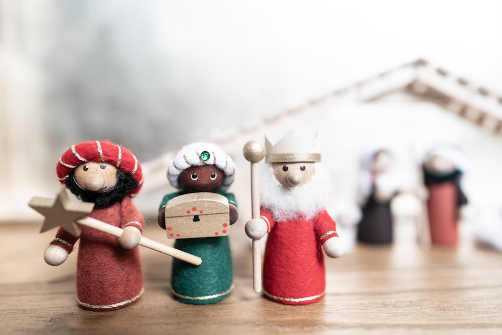 um grupo de pequenas figuras sentadas em cima de uma mesa de madeira