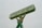 A large statue of a person holding up a rectangular sign above their head. The sign reads 'SALE OR LEASE' with a phone number. The statue is painted in shades of green, with a slightly weathered appearance.