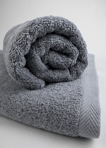 a gray towel folded on top of a bed