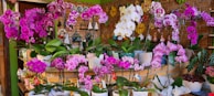 A bathroom shelf decorated with vibrant potted orchids adding a splash of color.