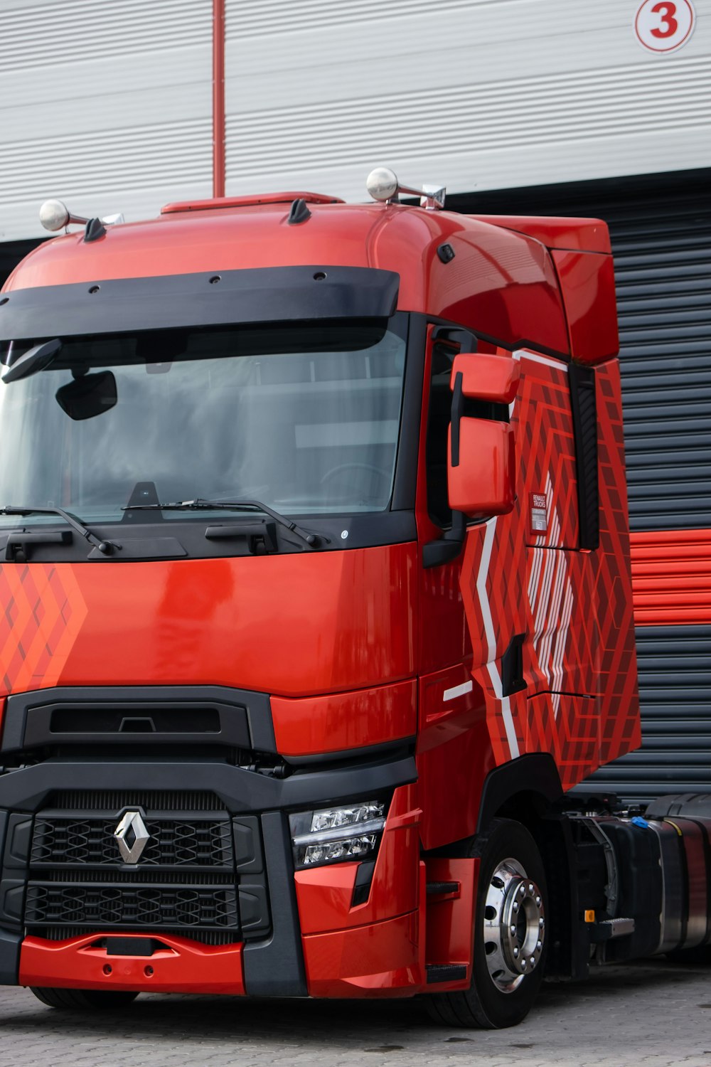 a red semi truck parked in front of a building