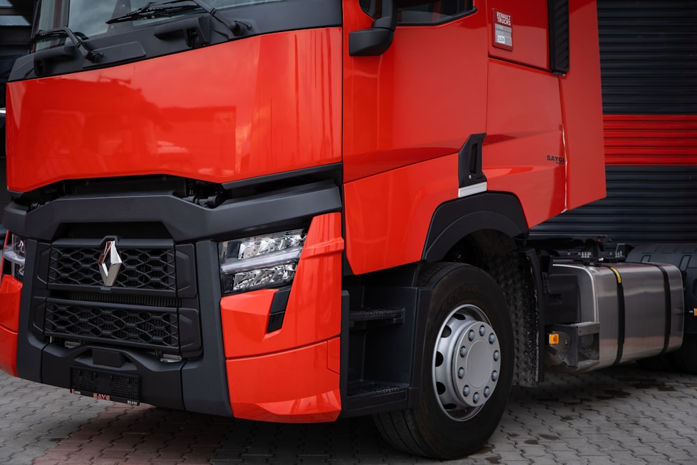 a large red truck parked next to a building