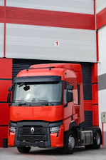 a red truck parked in front of a garage