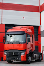 a red truck parked in front of a garage