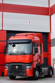 a red truck parked in front of a garage