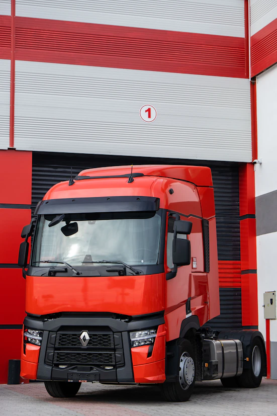 a red truck parked in front of a garage