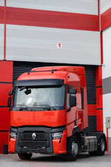 a red truck parked in front of a garage