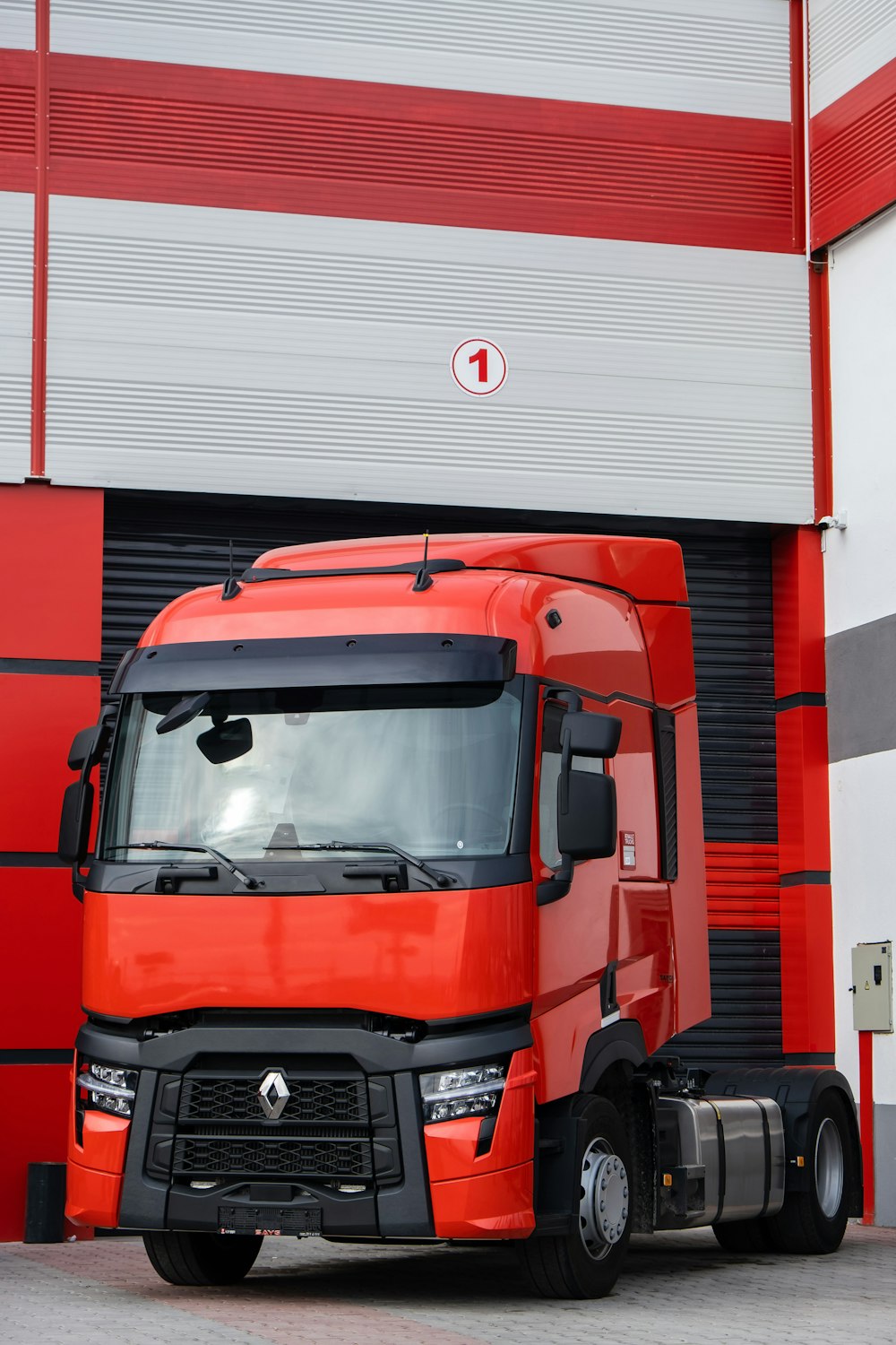 a red truck parked in front of a garage