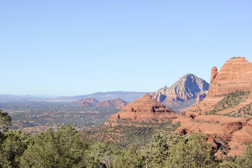 a scenic view of a mountain range with trees in the foreground