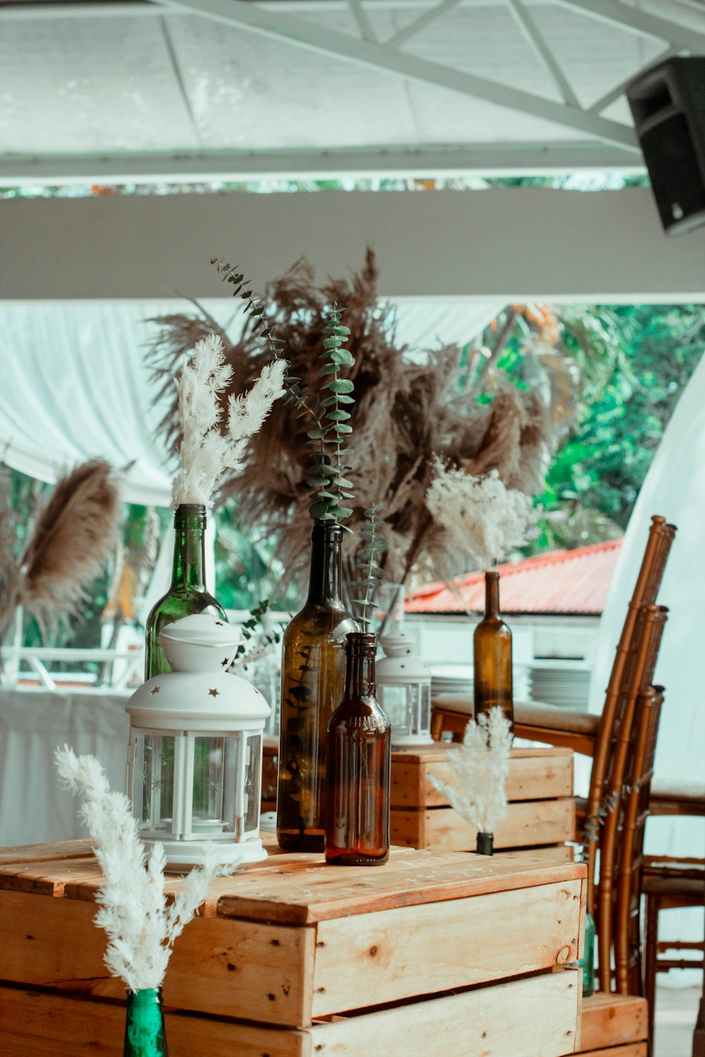 a wooden table topped with bottles filled with flowers