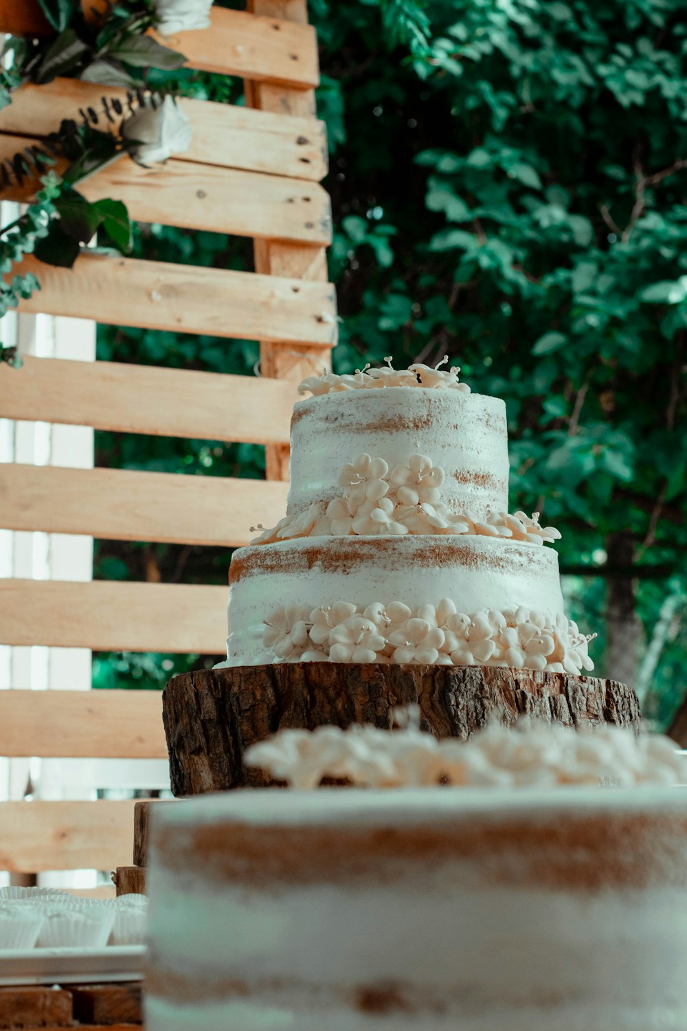 a three layer cake sitting on top of a wooden table