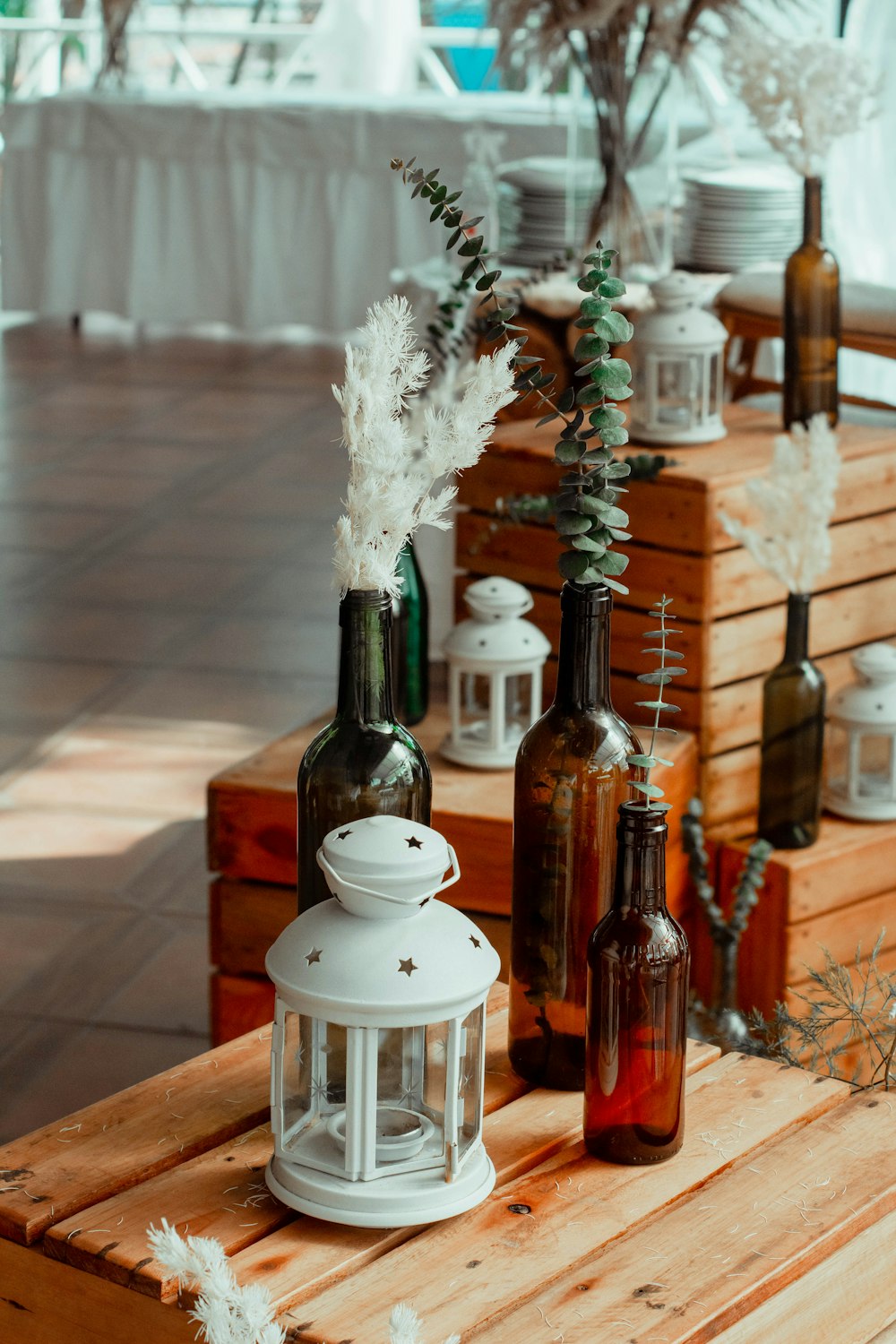 a wooden table topped with bottles filled with flowers
