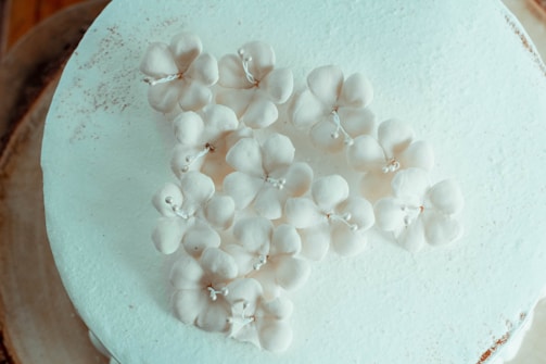 An elegant wedding cake with white frosting and delicate decorations.