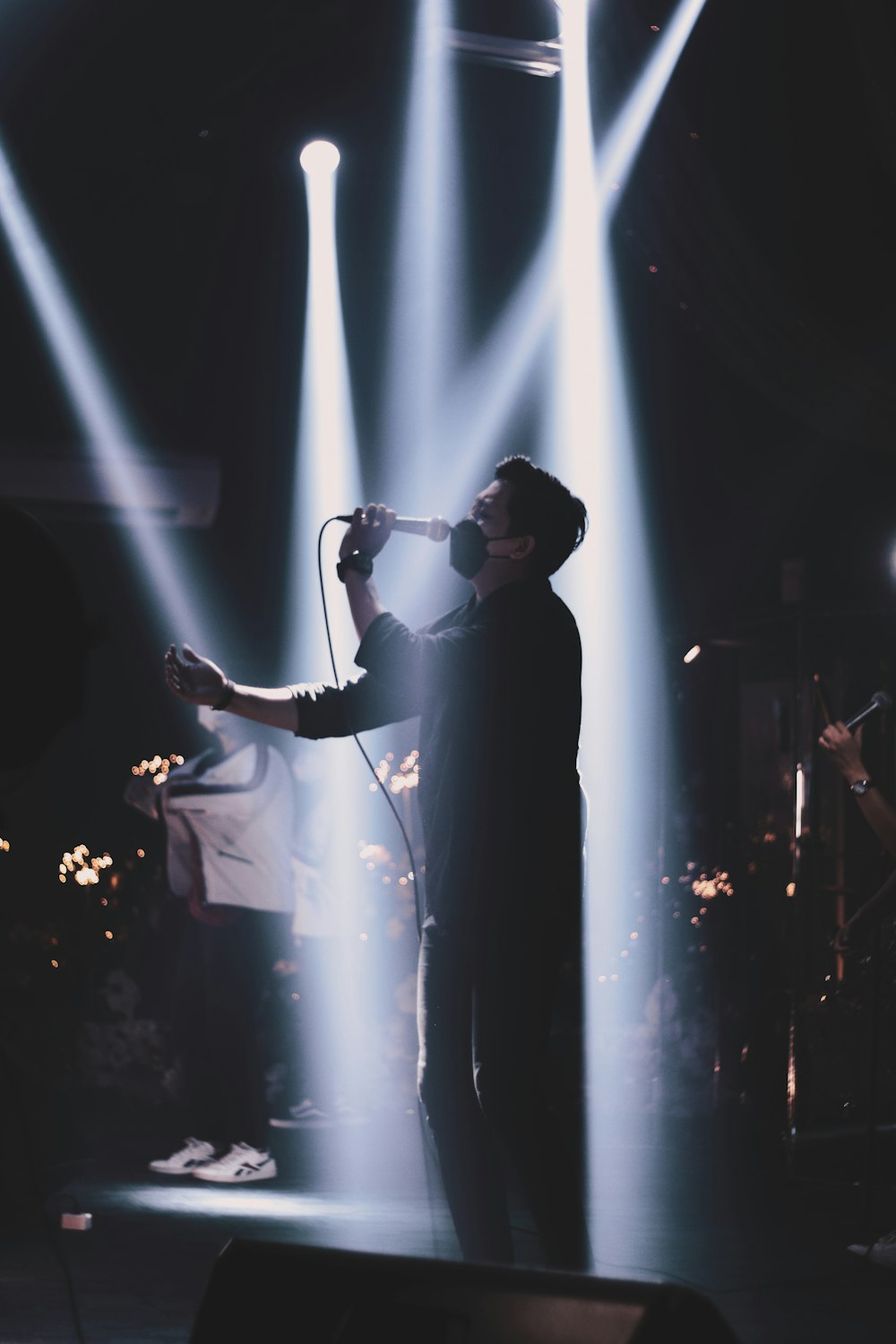 a man standing in front of a microphone on a stage