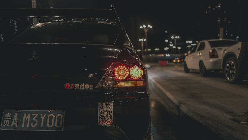 a car parked on the side of the road at night