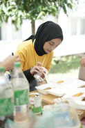 a woman sitting at a table with a plate of food
