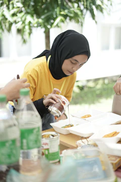 a woman sitting at a table with a plate of food