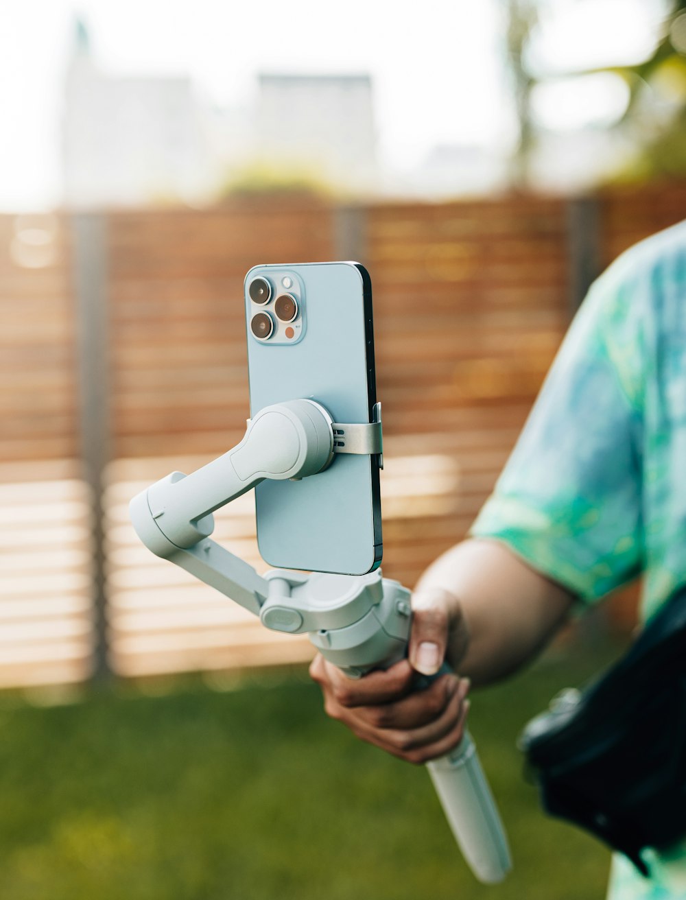 uma pessoa segurando um telefone celular com uma câmera conectada a ele