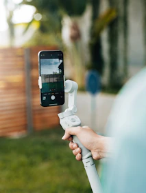 A lifestyle shot of a creator filming content outdoors, using the haloo bottle’s magnetic ring as a phone stand on a wooden table.