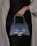 A stylish woman holding a preloved luxury bag from leatherbag.store.
