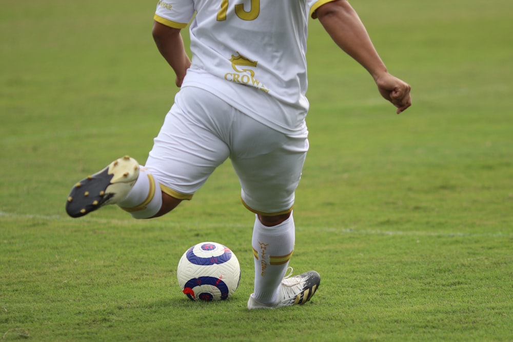 a man in a uniform kicking a soccer ball