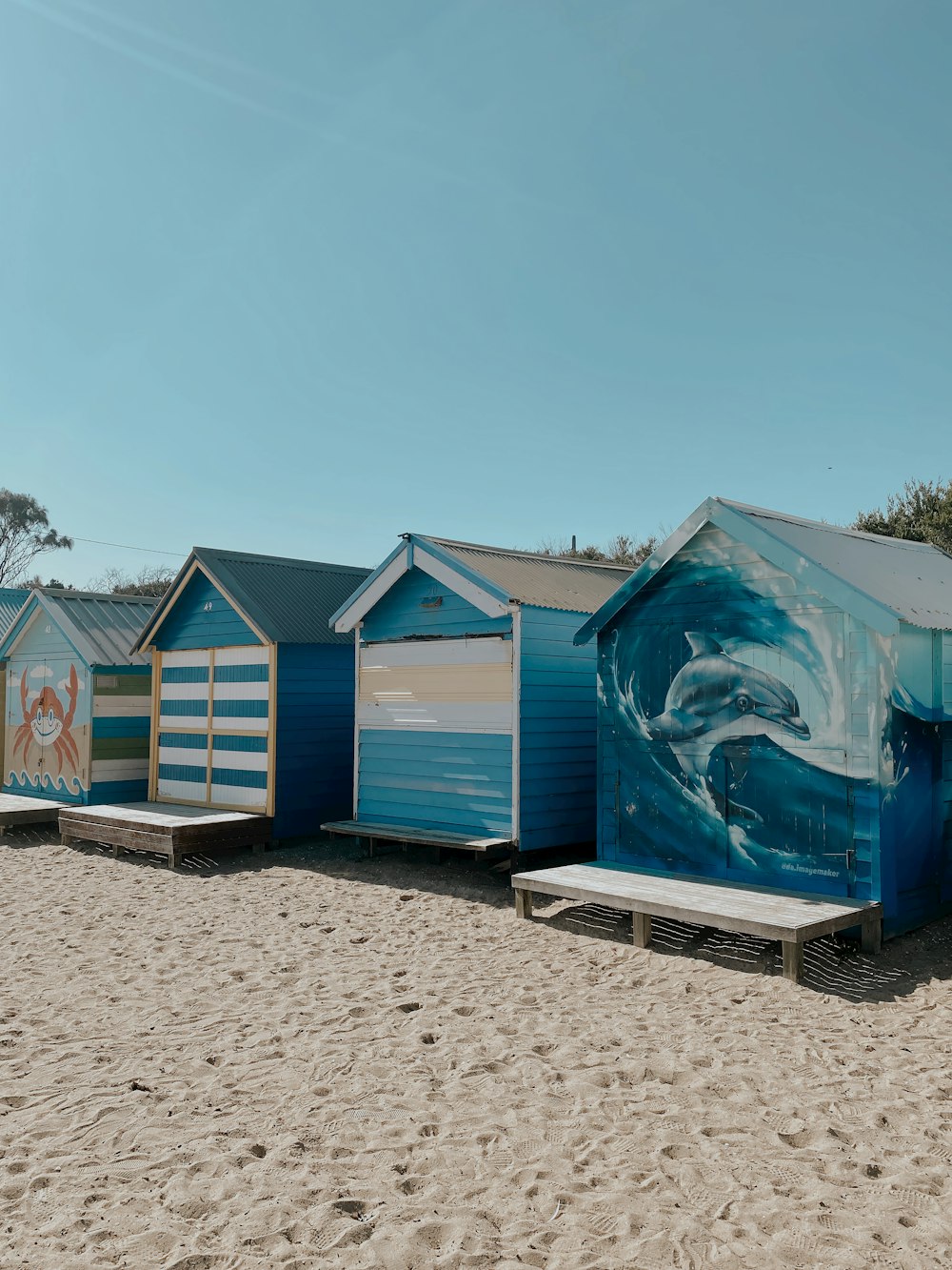 a row of beach huts sitting on top of a sandy beach