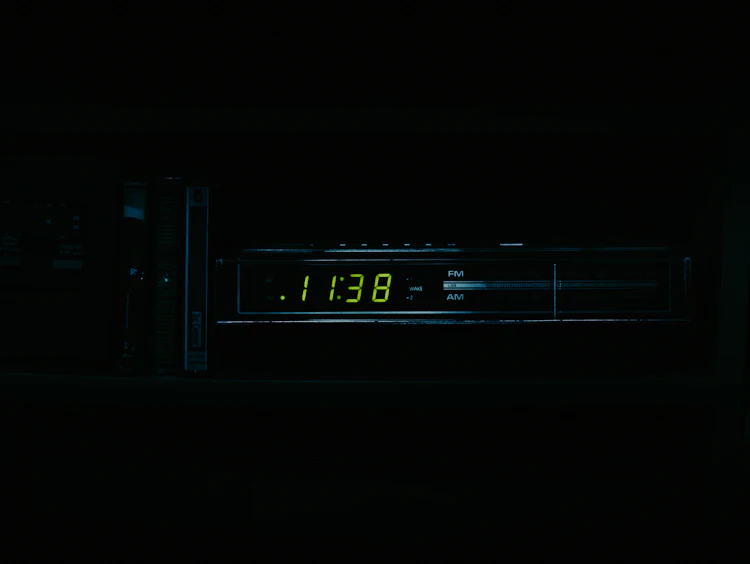 A clock glowing in a dark room at night