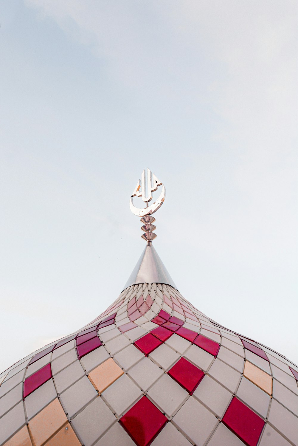 a building with a colorful roof and an arabic symbol on top of it