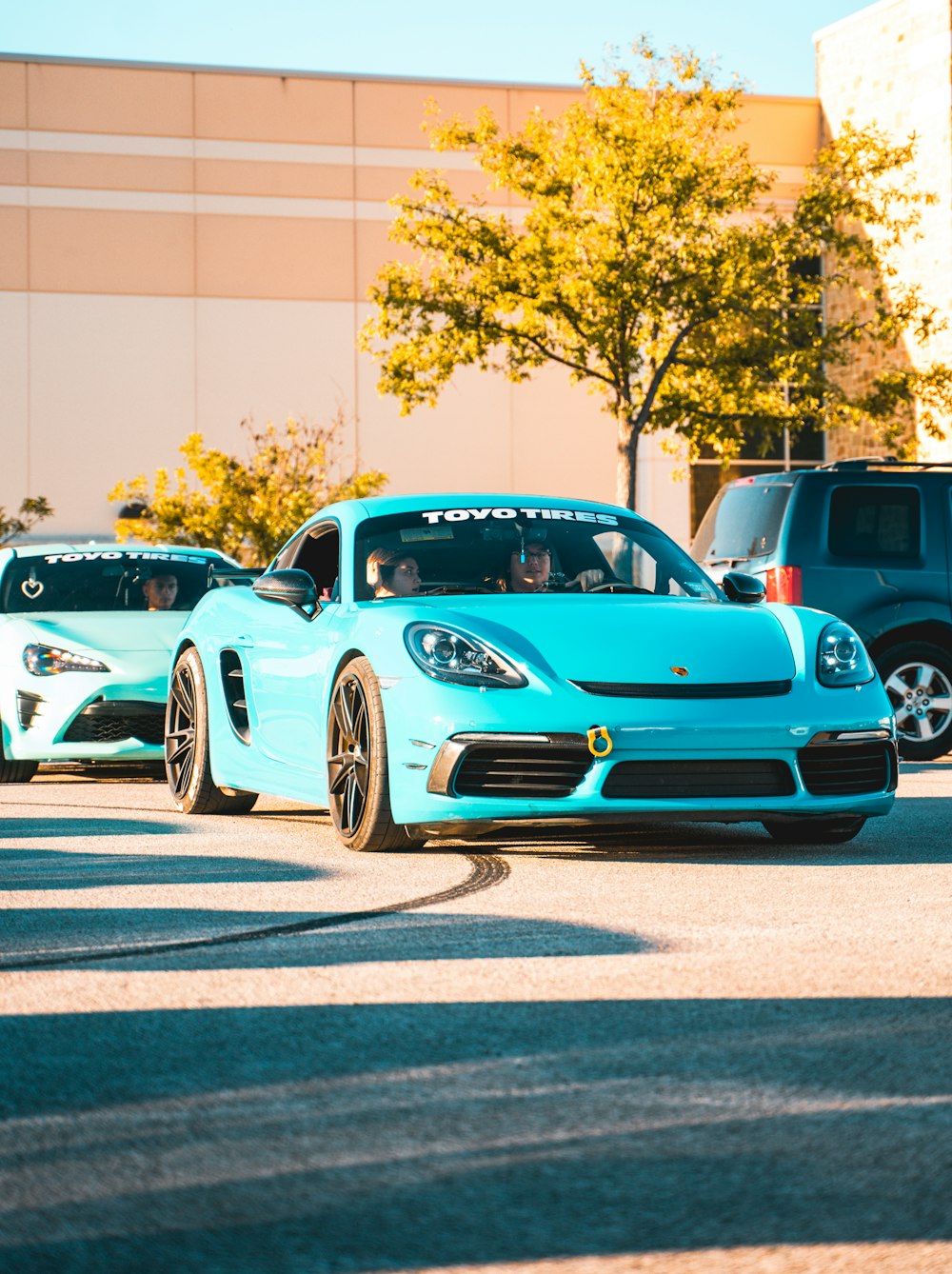 a blue sports car driving down a street