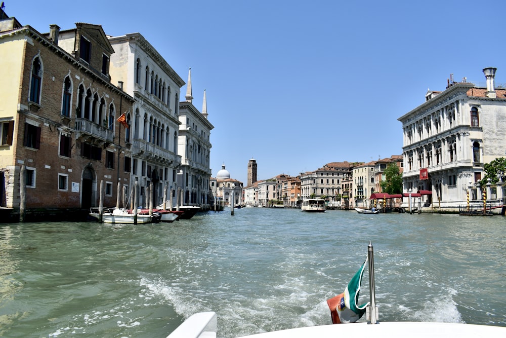 a boat traveling down a river next to tall buildings