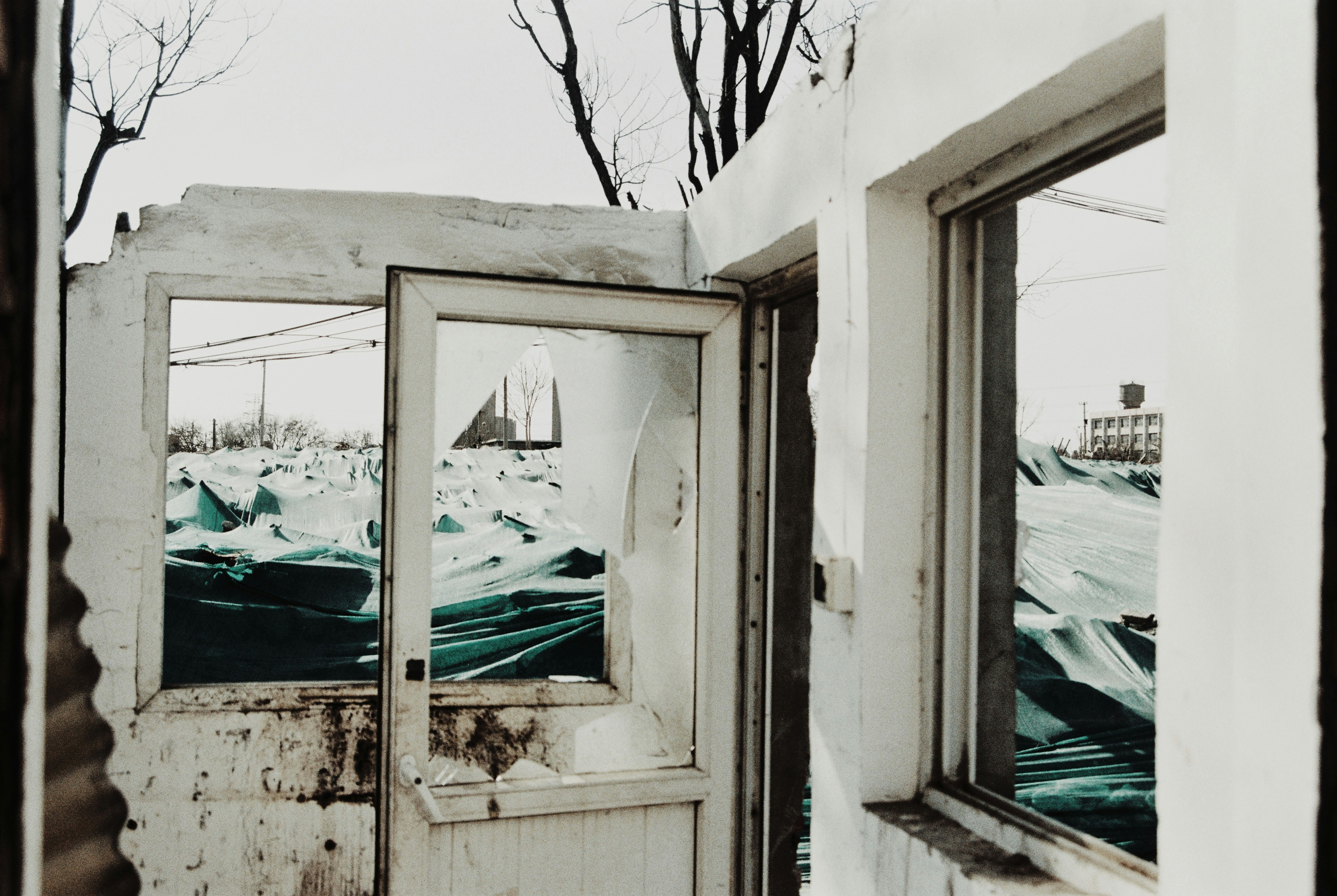 a broken down building with a broken glass door