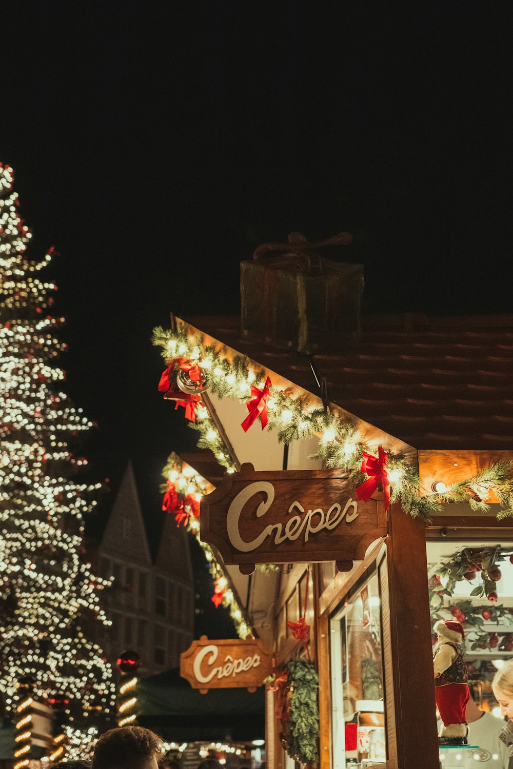 a lit up christmas tree in front of a store