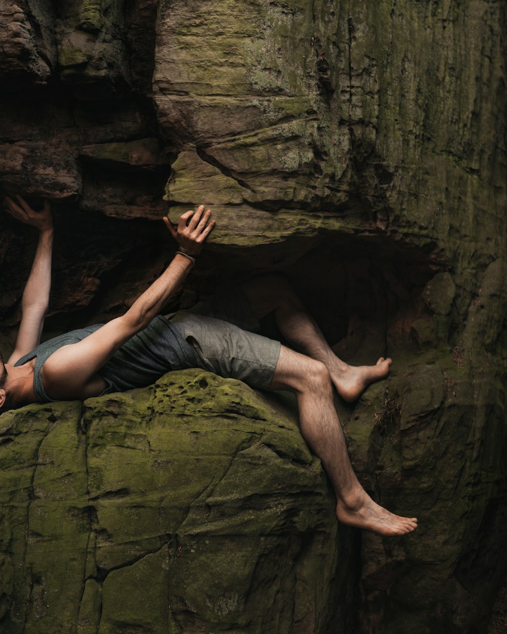 Un hombre acostado en la cima de una gran roca