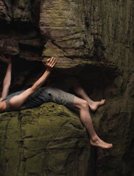 a man laying on top of a large rock