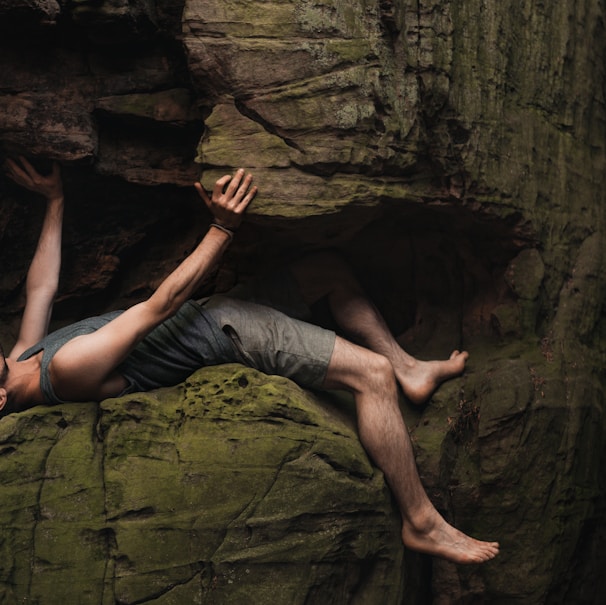 a man laying on top of a large rock