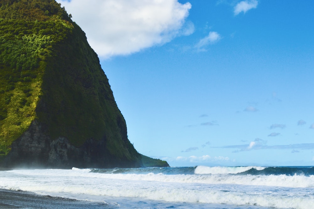 a man riding a surfboard on top of a wave covered beach