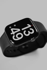 an apple watch with a black band and white numbers