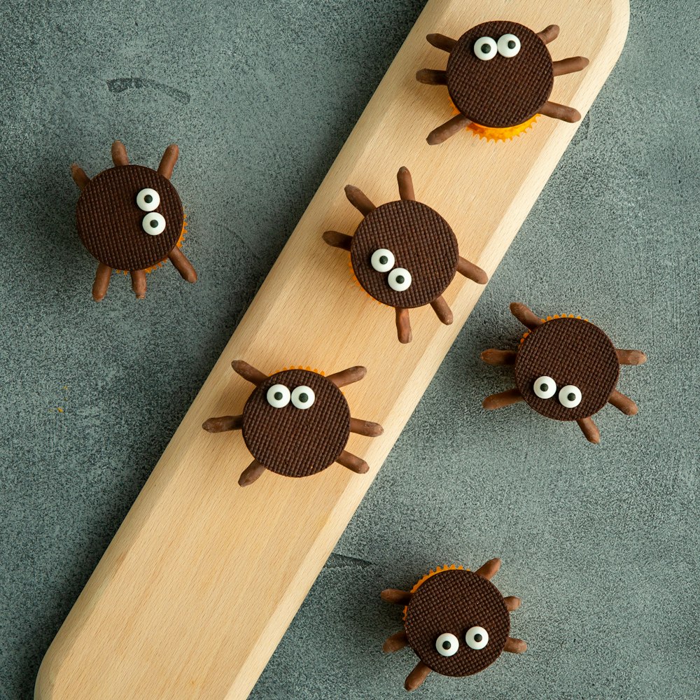 a wooden skateboard with three little monsters on it