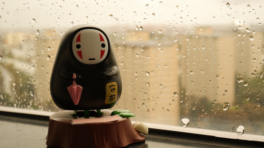 a small toy sitting on top of a window sill