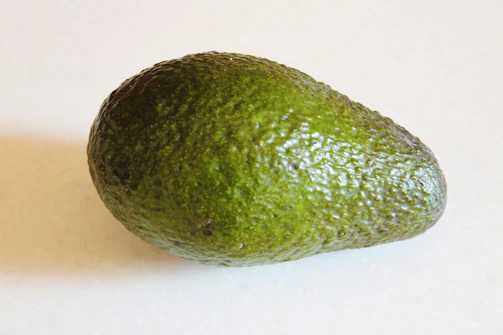 Close-up of ripe Haas avocados with deep navy and rich gold accents.