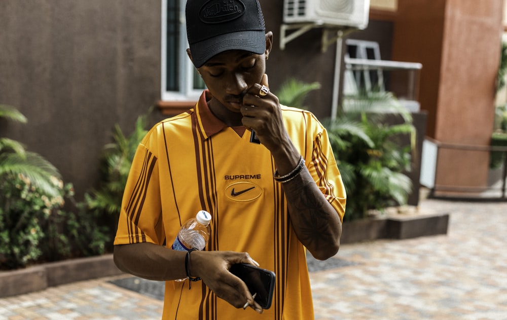 a man in a yellow shirt smoking a cigarette